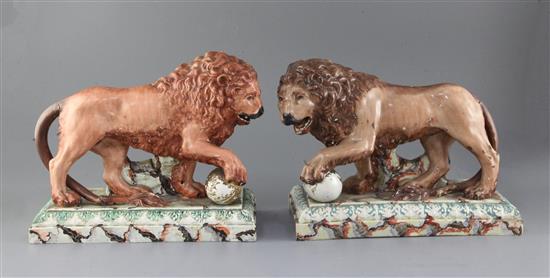 A near pair of Staffordshire pearlware figures of lions, c.1800-10, length 32cm, restorations